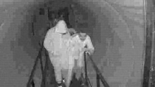 Grainy black-and-white surveillance-style frame from A24's Slayground teaser showing a figure inside a haunted attraction