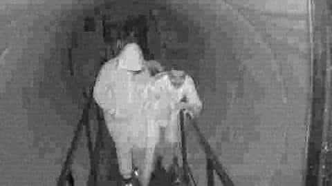 Grainy black-and-white surveillance-style frame from A24's Slayground teaser showing a figure inside a haunted attraction