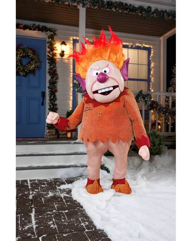 A Heat Miser animatronic with flaming orange hair on a snowy front walk