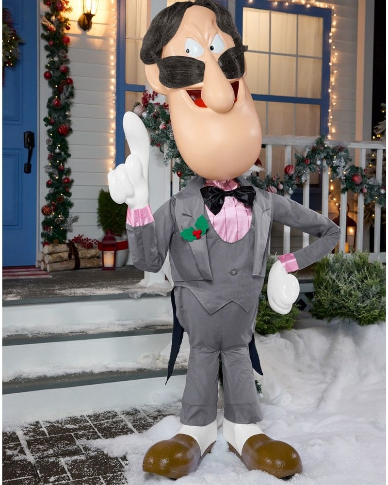 A Professor Hinkle magician animatronic in a gray suit and top hat on snowy front steps