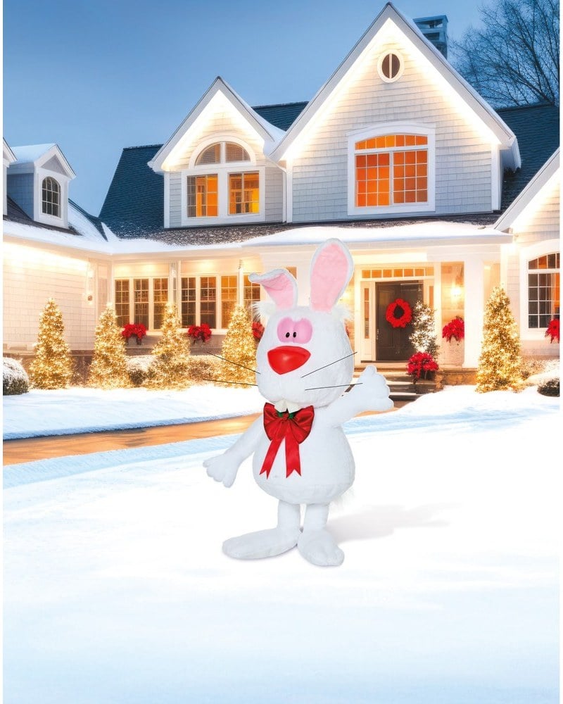 A white Hocus Pocus rabbit animatronic with a red bow tie on a snowy lawn