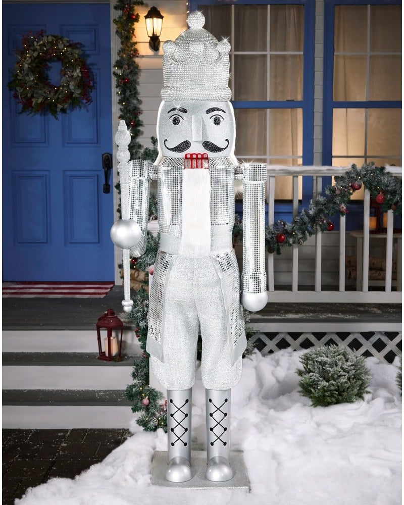 A 7-foot silver rhinestone nutcracker animatronic beside a front door