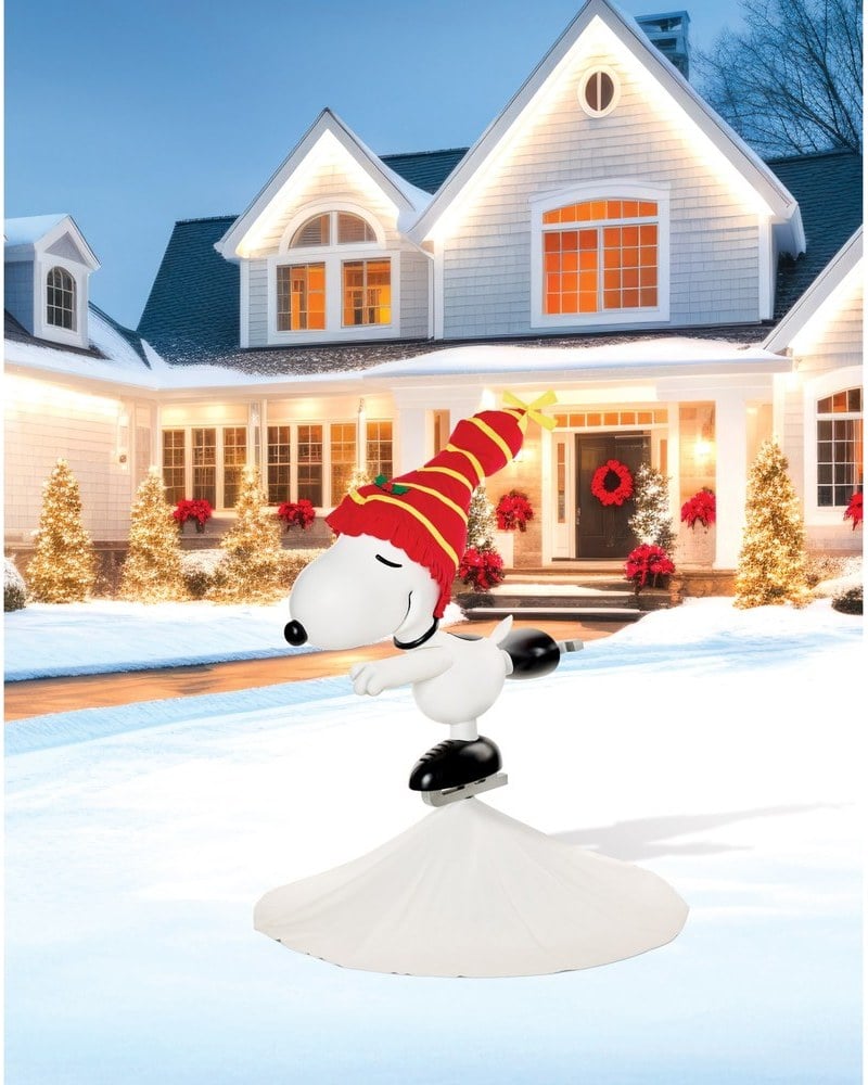 An ice skating Snoopy animatronic in a red hat spinning on a white base