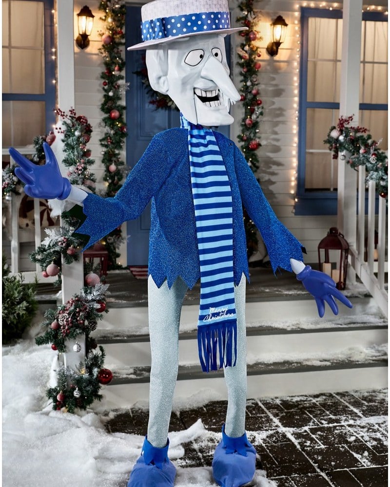 A Snow Miser animatronic in a blue suit and icicle hat on a snowy front lawn