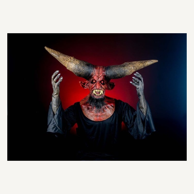 A person in a red devil mask with enormous horns stretching out to both sides