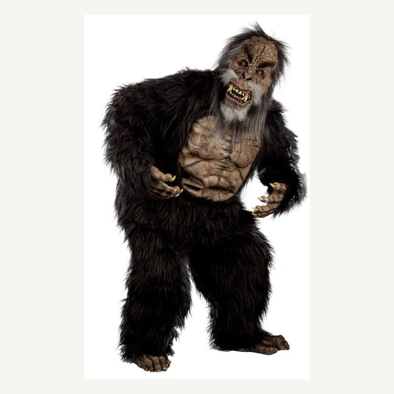 A performer in a full-body black-furred Sasquatch costume with a wrinkled brown face and clawed hands