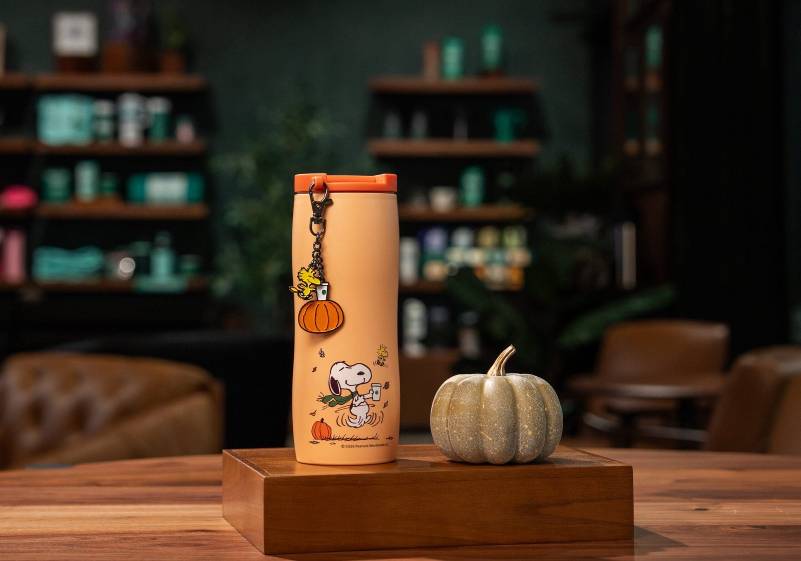Starbucks and Peanuts orange 16-ounce stainless steel tumbler with a dancing Snoopy and a Woodstock pumpkin charm