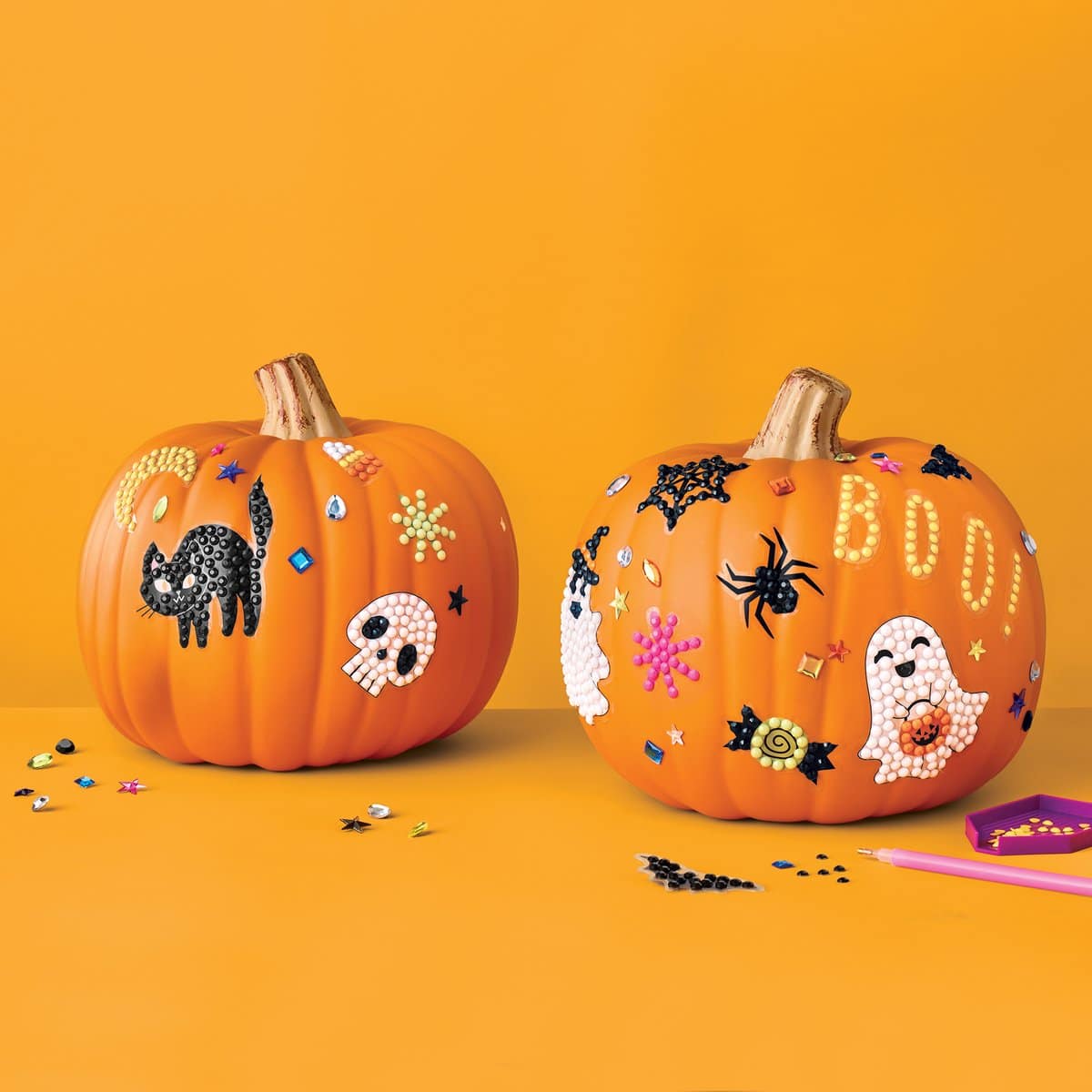 Two pumpkins decorated with Target gem art Halloween DIY kits
