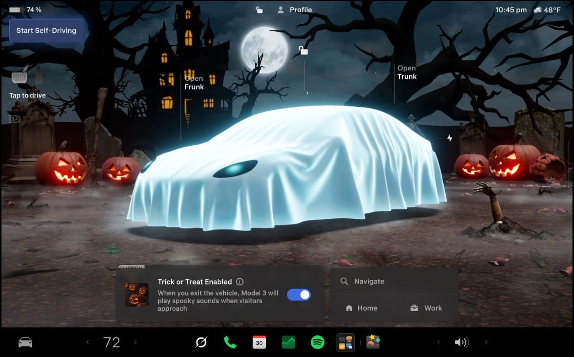 A car touchscreen shows a sheet-covered car in a graveyard with jack-o'-lanterns, and a switch at the bottom labeled Trick or Treat Enabled