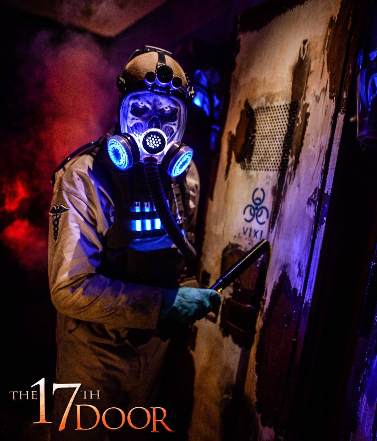 A character in a tan jumpsuit and a lit gas mask stands at a door marked Vixi with a biohazard symbol