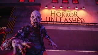 Zombie in front of the Universal Horror Unleashed sign for the Resident Evil takeover