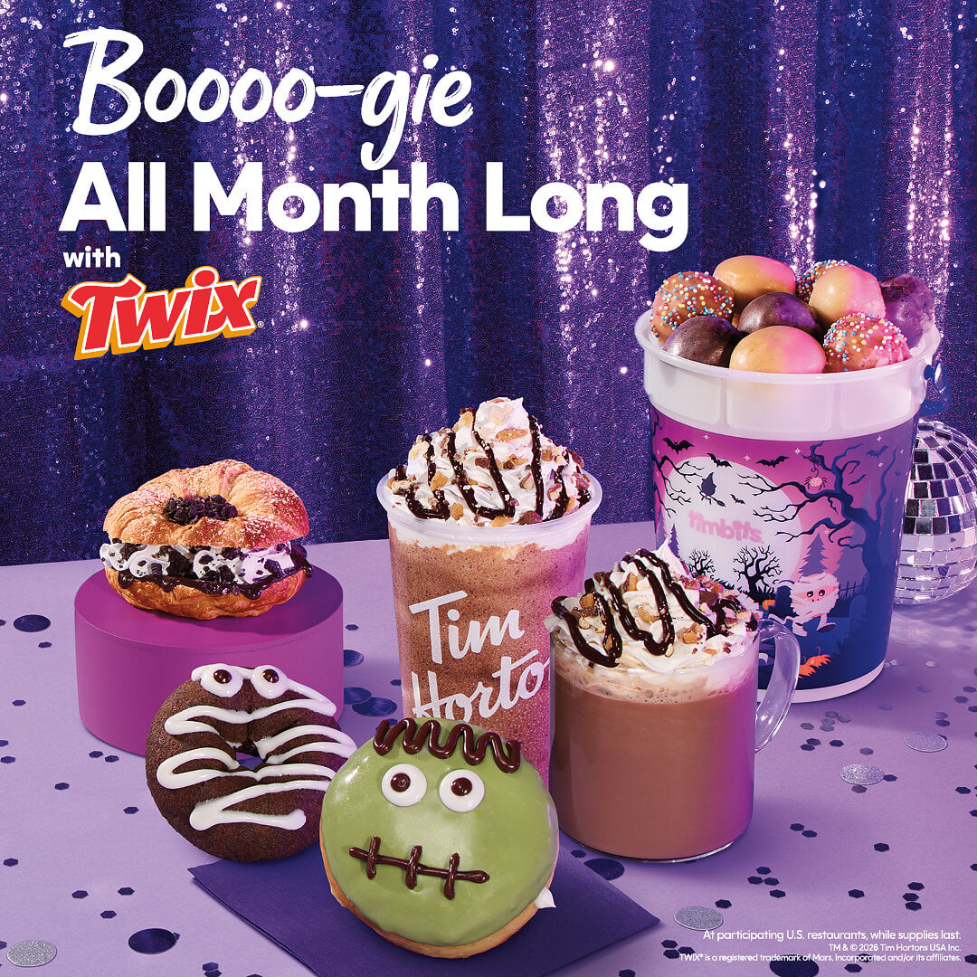 Tim Hortons Mummy and Frankenstein donuts, an OREO croissant, TWIX drinks, and a Timbits Trick-or-Treat Bucket on a purple table