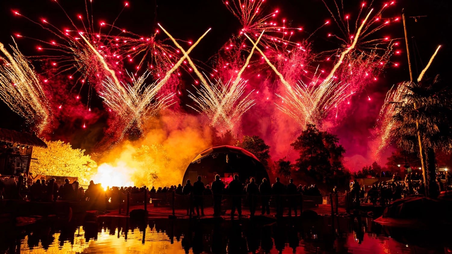 Red and gold fireworks over the crowd at the water in Port Laguna at the end of a Toverland Halloween Night