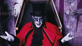 A costumed Ghost Train character in a top hat and red coat rising from a coffin at Tweetsie Railroad