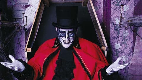 A costumed Ghost Train character in a top hat and red coat rising from a coffin at Tweetsie Railroad