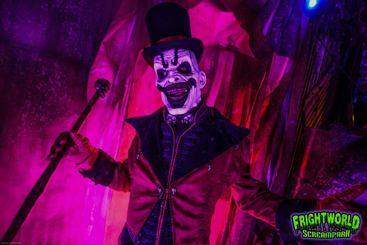 A pale, top-hatted ringmaster character with a skull-topped cane at Frightworld.