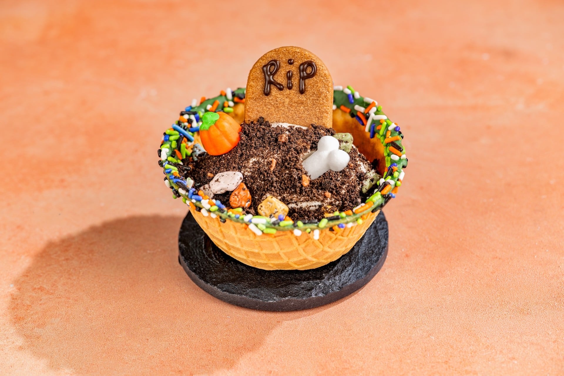 Boneyard Cookies and Scream Sundae in a waffle bowl with a tombstone cookie, sugar bone and pumpkin candy