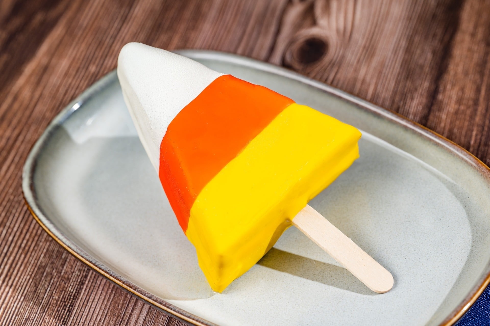 Candy Corn Pop, a candy corn shaped cheesecake bar on a stick