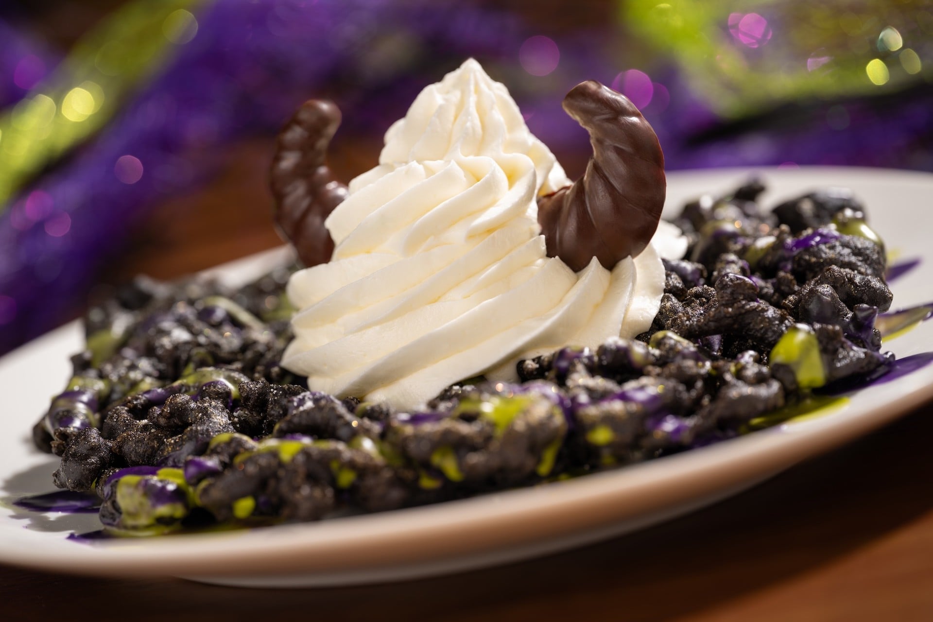 Maleficent Funnel Cake with purple and green icing, vanilla soft-serve and chocolate horns